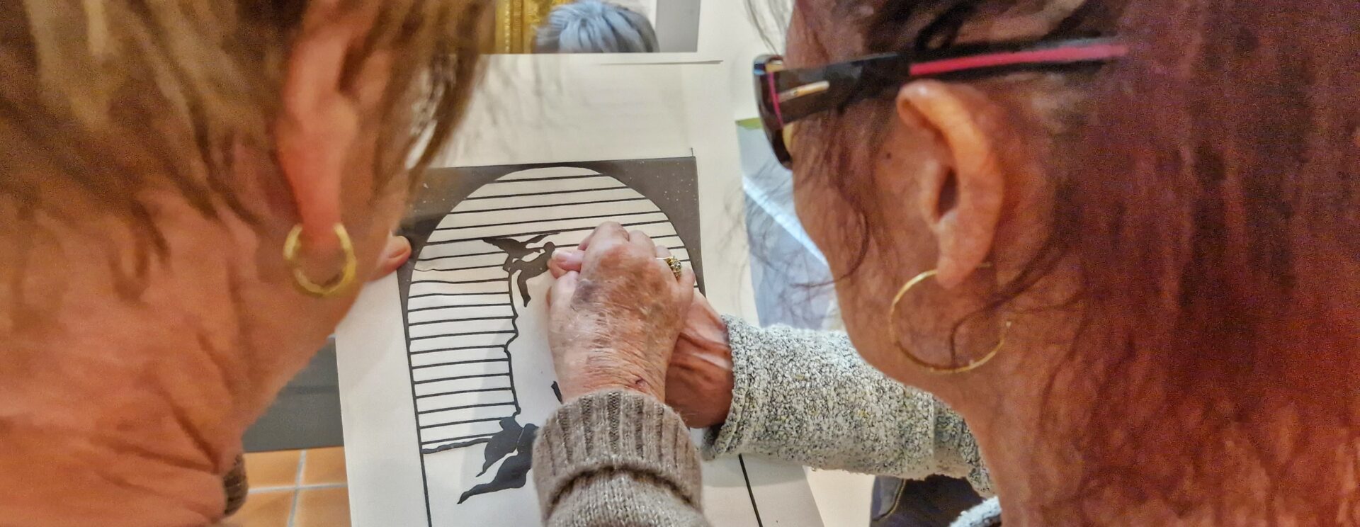 Deux personnes touchent une reproduction sur papier thermogonflé de la sculpture Léda et le cygne de Jean Esprit Marcellin.