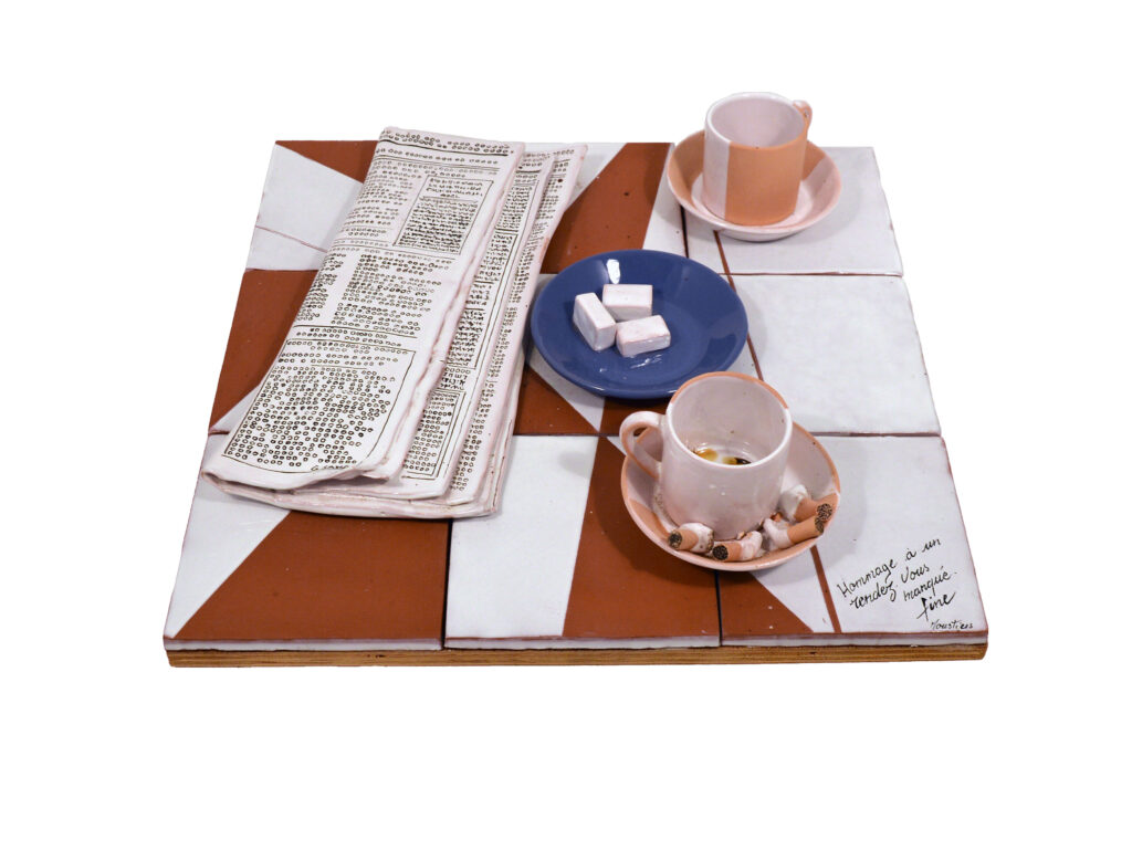 Création en céramique de Michel Fine représentant le plateau d'une table avec deux tasses de café, un journal et du sucre en morceaux intitulée 'Hommage à un rendez-vous manqué" - Agrandir l'image, fenêtre modale
